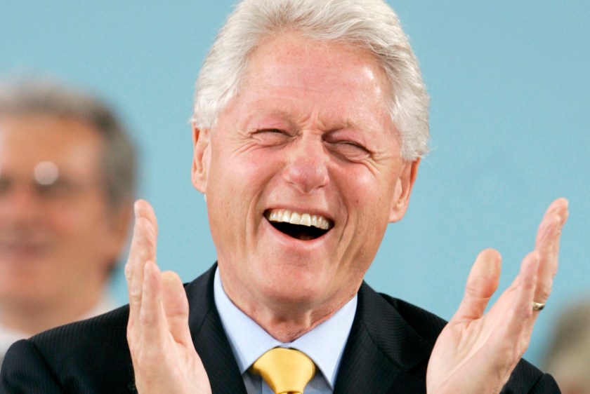 Former U.S. President Clinton laughs during the student speeches in Cambridge