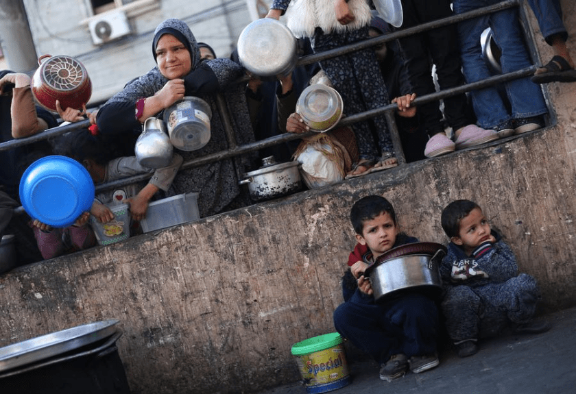 People wait for food relief in the southern Gaza Strip city of Rafah on March 14, 2024. (Photo by Khaled Omar/Xinhua)