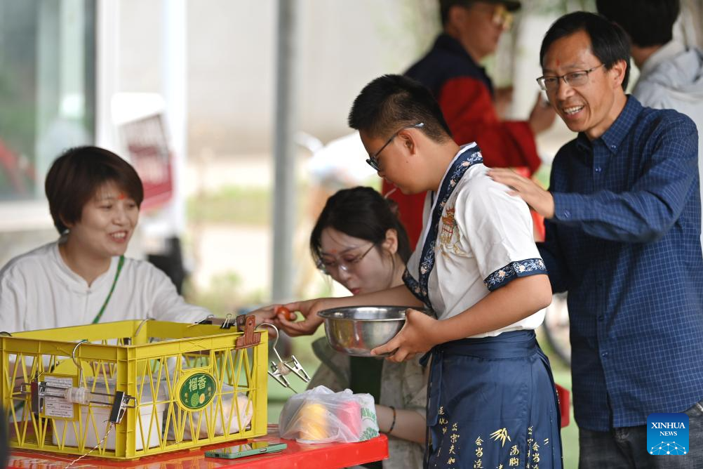 child distributes tomatoes at Huiai Farm in Yangliuqing Town, Xiqing District, north China's Tianjin,