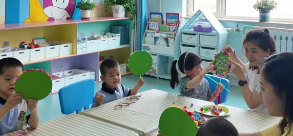 Children make paper ornaments with their teachers at Harbin Children's Home in Harbin, northeast China's Heilongjiang Province, May 30, 2025. (Xinhua/Shen Yijin)