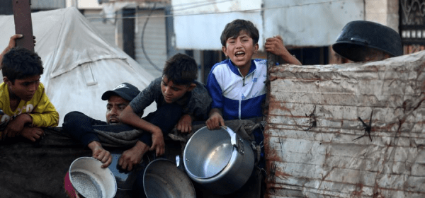 Palestinians wait to receive food in the Al-Rimal neighborhood of central Gaza City, on July 20, 2025. (Photo by Rizek Abdeljawad/Xinhua)