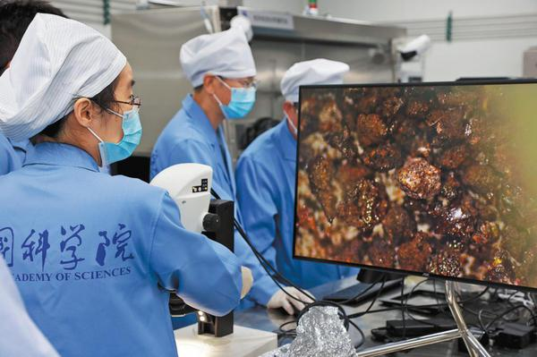A researcher from the National Astronomical Observatories of the Chinese Academy of Sciences examines in July last year a microscopic image of lunar rock and soil fragments that were collected by the Chang'e 6 probe from the far side of the moon. (PROVIDED TO CHINA DAILY)