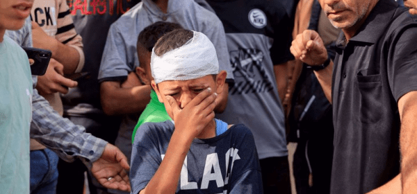 An injured Palestinian child, Yousef Al-Bayouk, weeps over his brothers, Moath and Moataz, who were killed in Israeli strikes, at their funeral in the southern Gaza Strip on May 15, 2025. (Reuters photo)