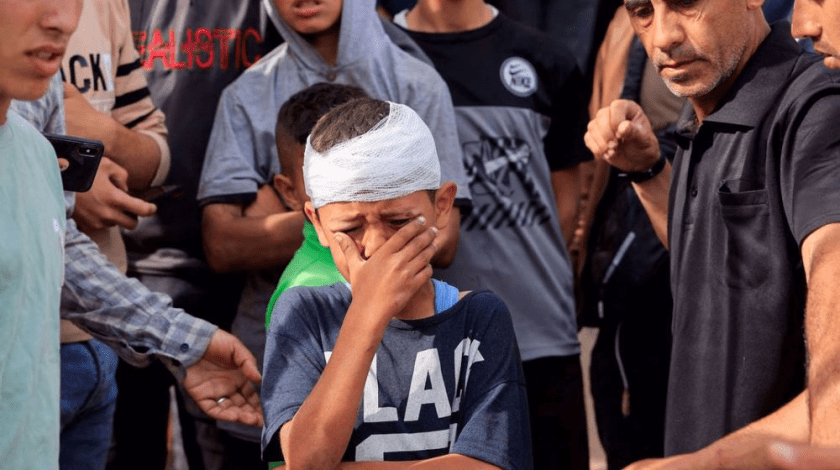 An injured Palestinian child, Yousef Al-Bayouk, weeps over his brothers, Moath and Moataz, who were killed in Israeli strikes, at their funeral in the southern Gaza Strip on May 15, 2025. (Reuters photo)