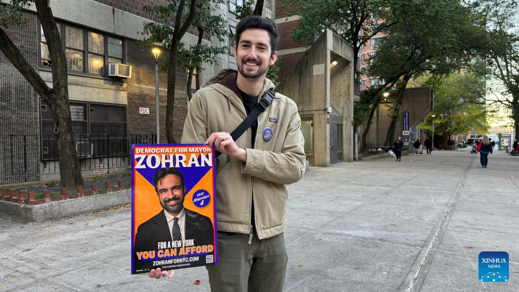 This photo taken with a mobile phone shows a supporter presenting a poster of Democratic candidate Zohran Mamdani during the New York City mayoral election in New York City, the United States, Nov. 4, 2025. Democratic candidate Zohran Mamdani won the New York City mayoral election Tuesday night, becoming the first muslim mayor of the most populous city in the United States. (Photo by Winston Zhou/Xinhua)