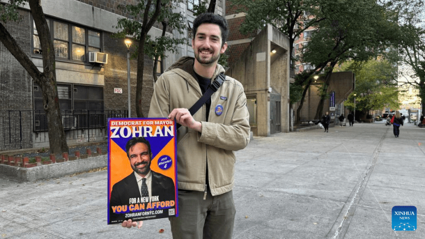 This photo taken with a mobile phone shows a supporter presenting a poster of Democratic candidate Zohran Mamdani during the New York City mayoral election in New York City, the United States, Nov. 4, 2025. Democratic candidate Zohran Mamdani won the New York City mayoral election Tuesday night, becoming the first muslim mayor of the most populous city in the United States. (Photo by Winston Zhou/Xinhua)