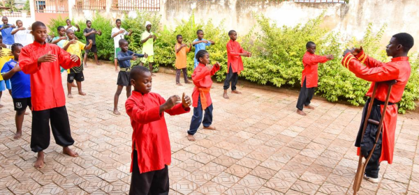 Martin Mangwandjo (1st R), a disabled Cameroonian, leads young learners in practicing Chinese martial arts moves at his training centre in Yaounde, Cameroon's capital, Nov. 18, 2025. (Photo by Kepseu/Xinhua)
