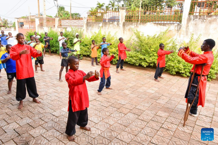 Martin Mangwandjo (1st R), a disabled Cameroonian, leads young learners in practicing Chinese martial arts moves at his training centre in Yaounde, Cameroon's capital, Nov. 18, 2025. (Photo by Kepseu/Xinhua)