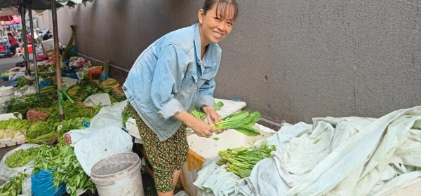 Chị Nguyễn Thị Tĩnh, một hộ nghèo nhờ vay vốn 100 triệu đồng (trong đợt 1 năm 2024) mở sạp rau tại chợ Văn Thánh đã thoát nghèo. Ảnh: HV