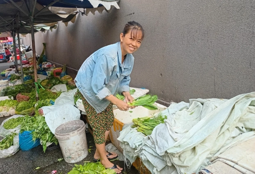 Chị Nguyễn Thị Tĩnh, một hộ nghèo nhờ vay vốn 100 triệu đồng (trong đợt 1 năm 2024) mở sạp rau tại chợ Văn Thánh đã thoát nghèo. Ảnh: HV
