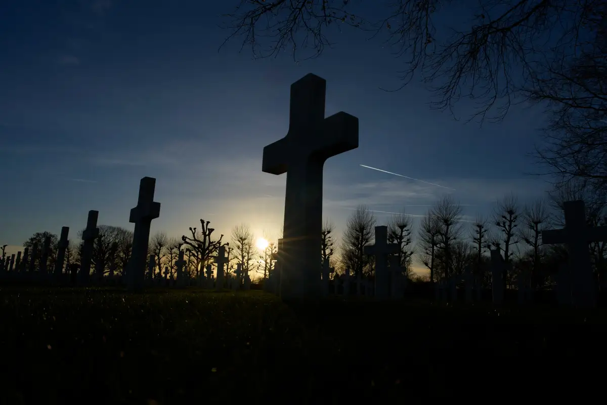 The sun sets over the graves of more than 8.300 WWII soldiers at the Netherlands American Cemetery in Margraten, Netherlands, Thursday, Dec. 11, 2025, where the American Battle Monuments Commission removed two displays honoring Black liberators from the visitors center. (AP Photo/Peter Dejong).