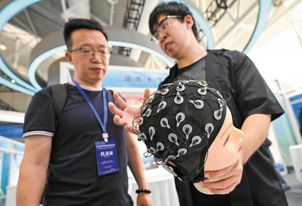 A visitor learns about a BCI system designed for amyotrophic lateral sclerosis patients at an industry - research cooperation conference at Nanjing International Exhibition Center, Jiangsu province, on Sept 12. (Photo / China Daily)