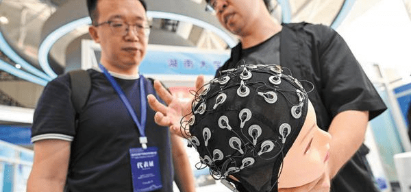 A visitor learns about a BCI system designed for amyotrophic lateral sclerosis patients at an industry - research cooperation conference at Nanjing International Exhibition Center, Jiangsu province, on Sept 12. (Photo / China Daily)