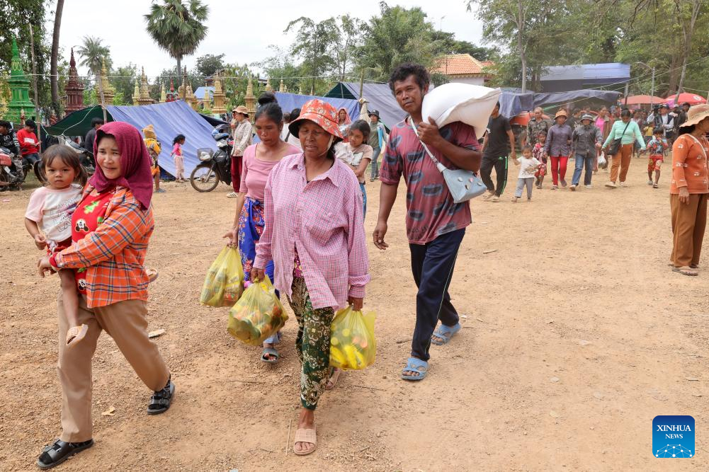 Cambodian evacuees carry relief items at a safe zone in Siem Reap province, Cambodia, on Dec. 11, 2025. (Photo by Sovannara/Xinhua)