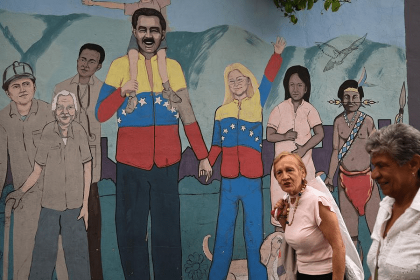 People walks past a mural in Caracas, Venezuela, Nov. 5, 2025. Venezuelan President Nicolas Maduro has repeatedly condemned Washington's actions as attempts to overthrow his government and expand the U.S. military influence in Latin America. (Photo by Marcos Salgado/Xinhua