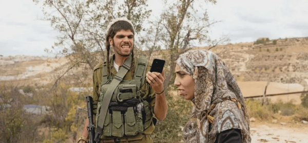 An armed Israeli settler films Meead Abu al-Rub in the occupied West Bank, 12 October 2025. The photograph, by Italian photographer Pietro Masturzo, featured on the front cover of L'Espresso magazine (Pietro Masturzo/L'Espresso)