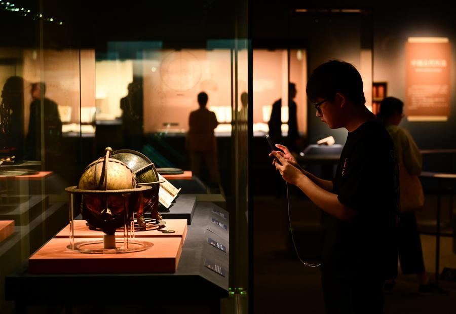 A visitor takes photos of an ancient astronomical instrument at an exhibition titled "Heavenly Questions: The Cosmological Vision of Chinese Civilization" at the Anhui Museum in Hefei, east China's Anhui Province, July 1, 2026. (Xinhua/Zhou Mu)