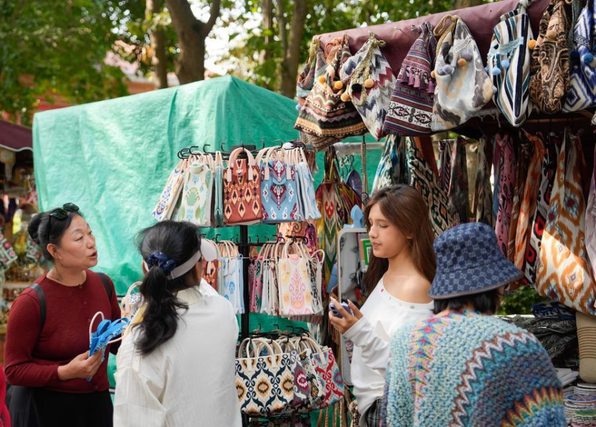Tourists buy souvenirs in Liuxing block of Yining, Ili Kazak Autonomous Prefecture, northwest China's Xinjiang Uygur Autonomous Region, Sept. 8, 2025. Liuxing block in Yining is named for its hexagonal alleys where people of multiple ethnic groups live together. (Xinhua/Zhang Haobo)