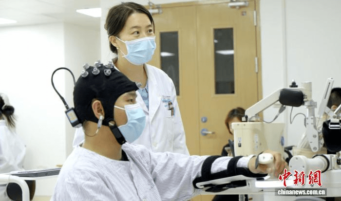 Medical staff use brain-computer interface equipment to conduct rehabilitation training for a patient at the Third Affiliated Hospital of Sun Yat-sen University in Guangzhou, south China's Guangdong Province. (Photo: The Third Affiliated Hospital of Sun Yat-sen University)