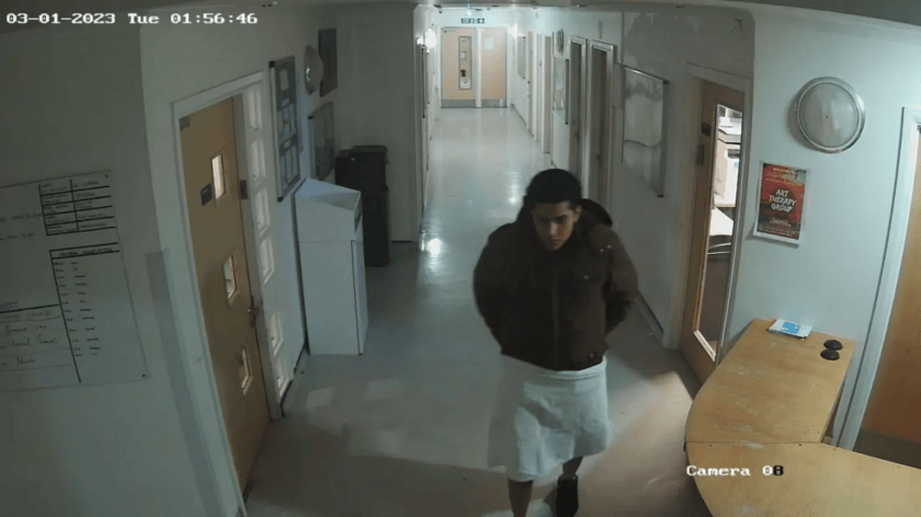 Rolando Torres-Pena walking in the unit, with his legs covered by material wrapped around his waist.