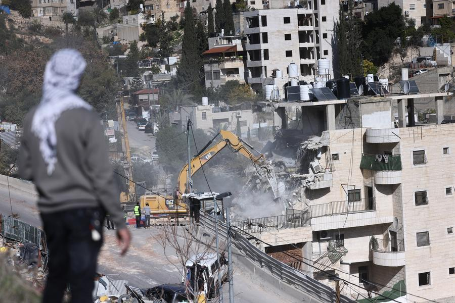 A Palestinian man watches as Israeli forces demolish a residential building in the Silwan neighborhood of east Jerusalem, on Dec. 22, 2025. (Photo by Jamal Awad/Xinhua)