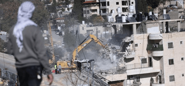 A Palestinian man watches as Israeli forces demolish a residential building in the Silwan neighborhood of east Jerusalem, on Dec. 22, 2025. (Photo by Jamal Awad/Xinhua)