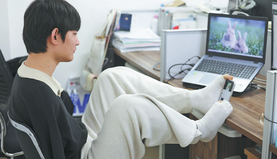 Wang Haigang works in his dorm room at the campus of Taiyuan University of Technology in Jinzhong city, Shanxi province. Photo/China Dai!
